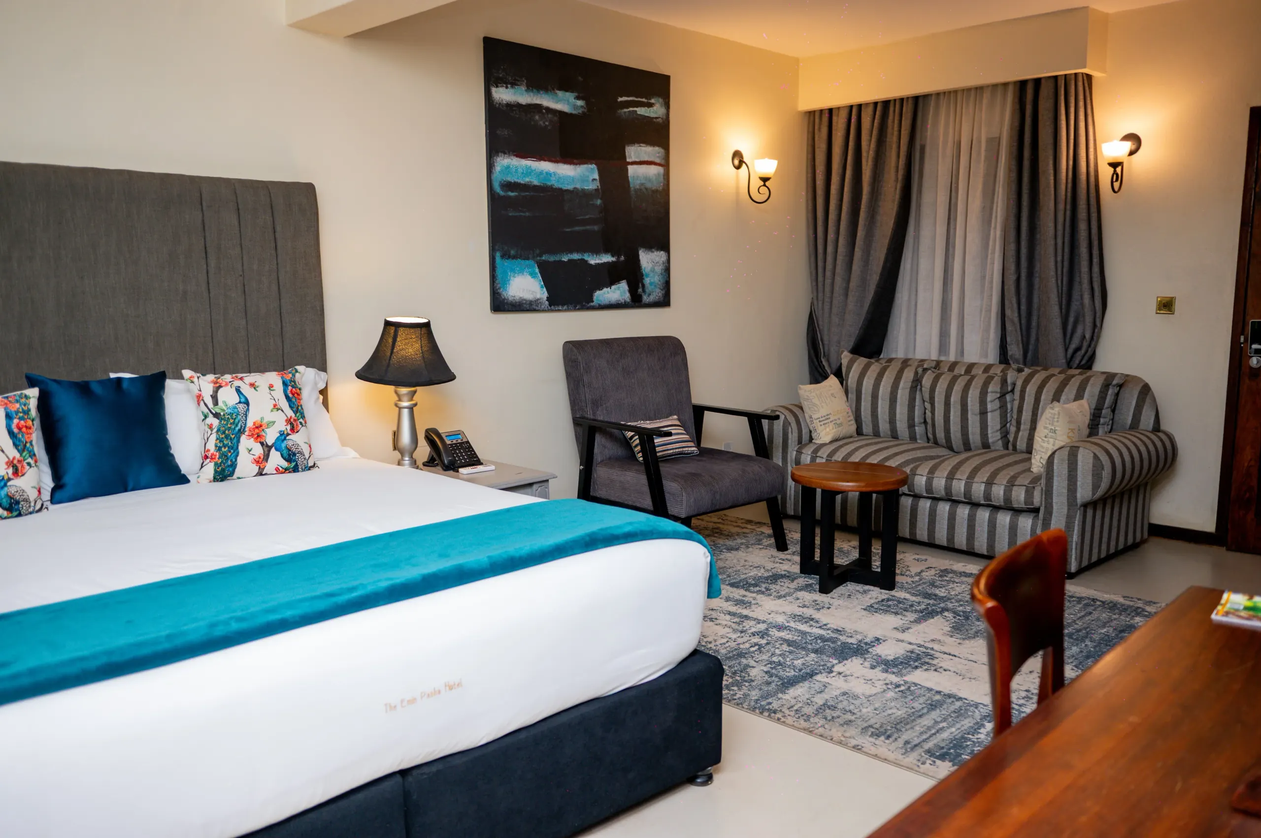 The seating area of a Deluxe Suite at The Emin Pasha Hotel & Spa, with an armchair and sofa