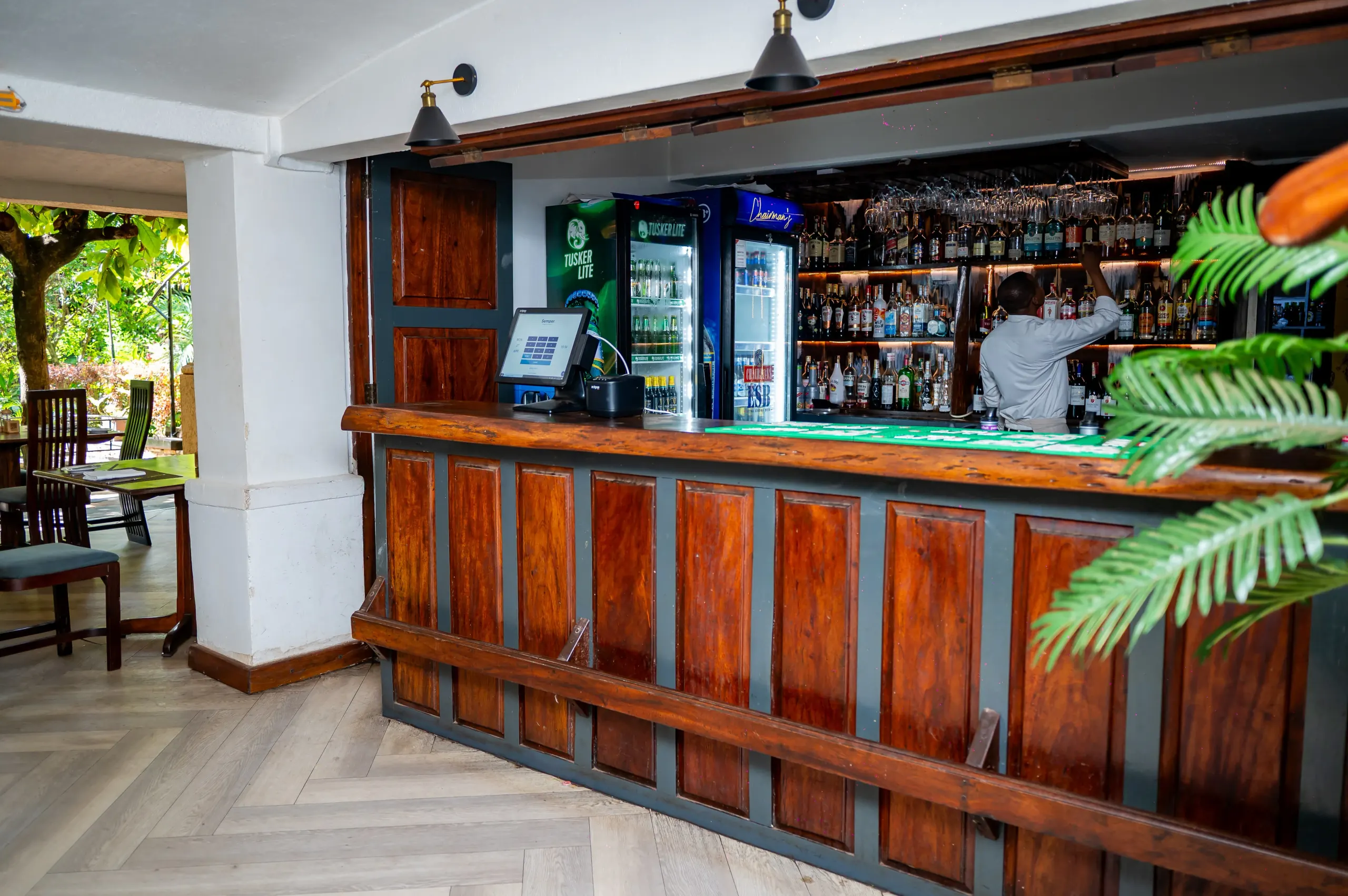 A bartender at Manutea's back bar among the spirits