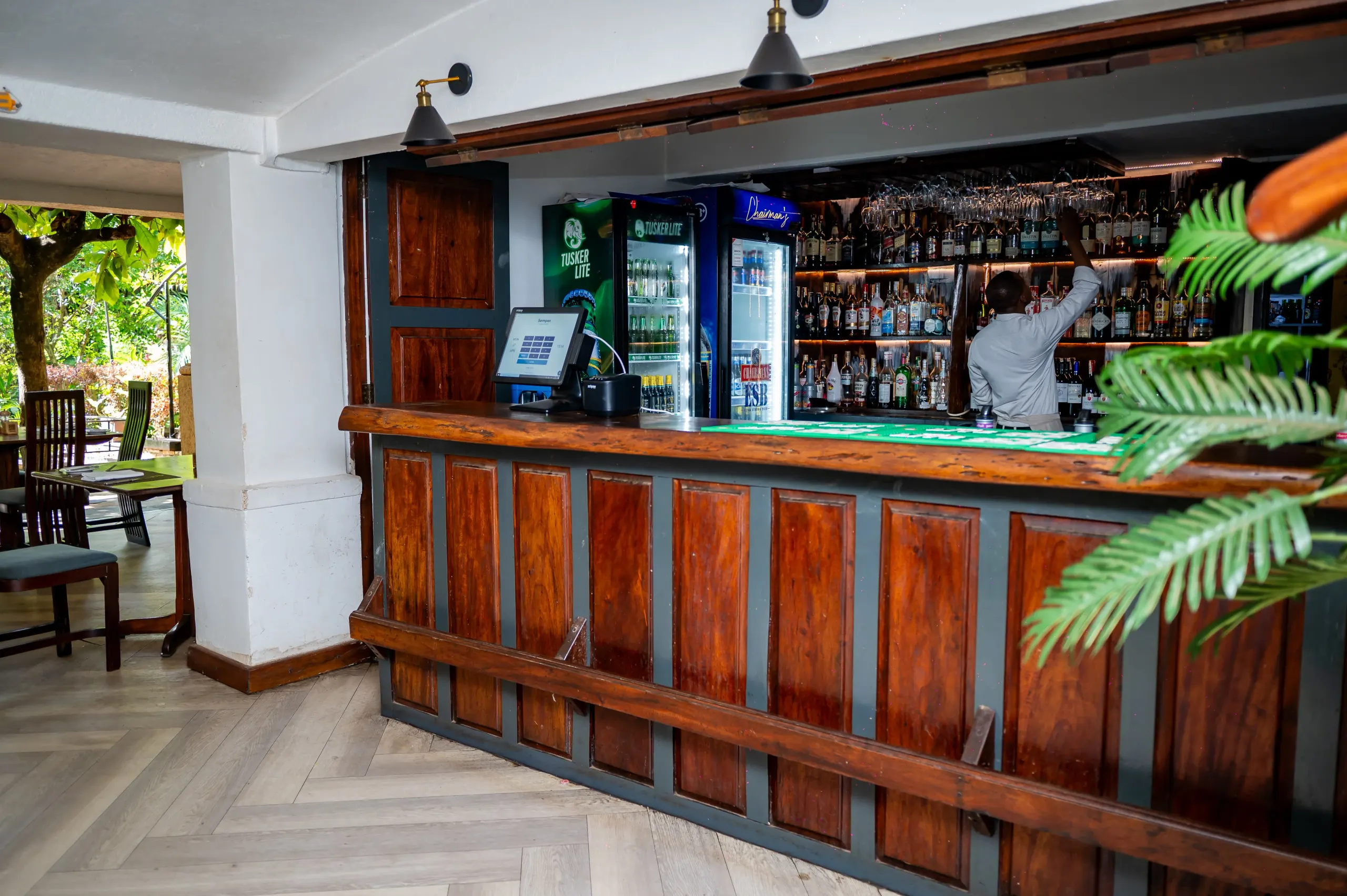 Manutea's bar from the side, a bartender reaching to the top shelf