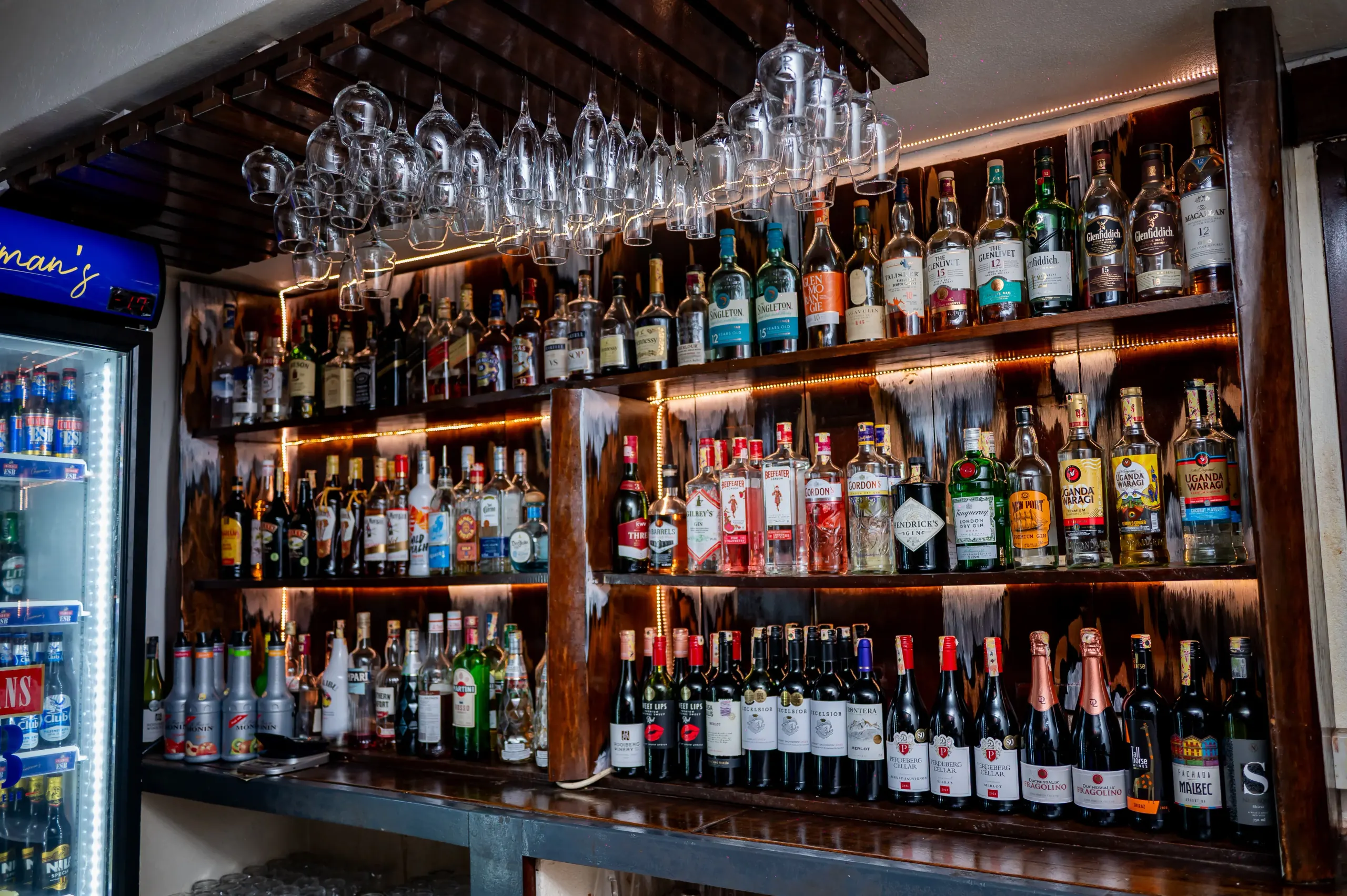Manutea's back bar: whisky, gin and wine beneath hanging glassware