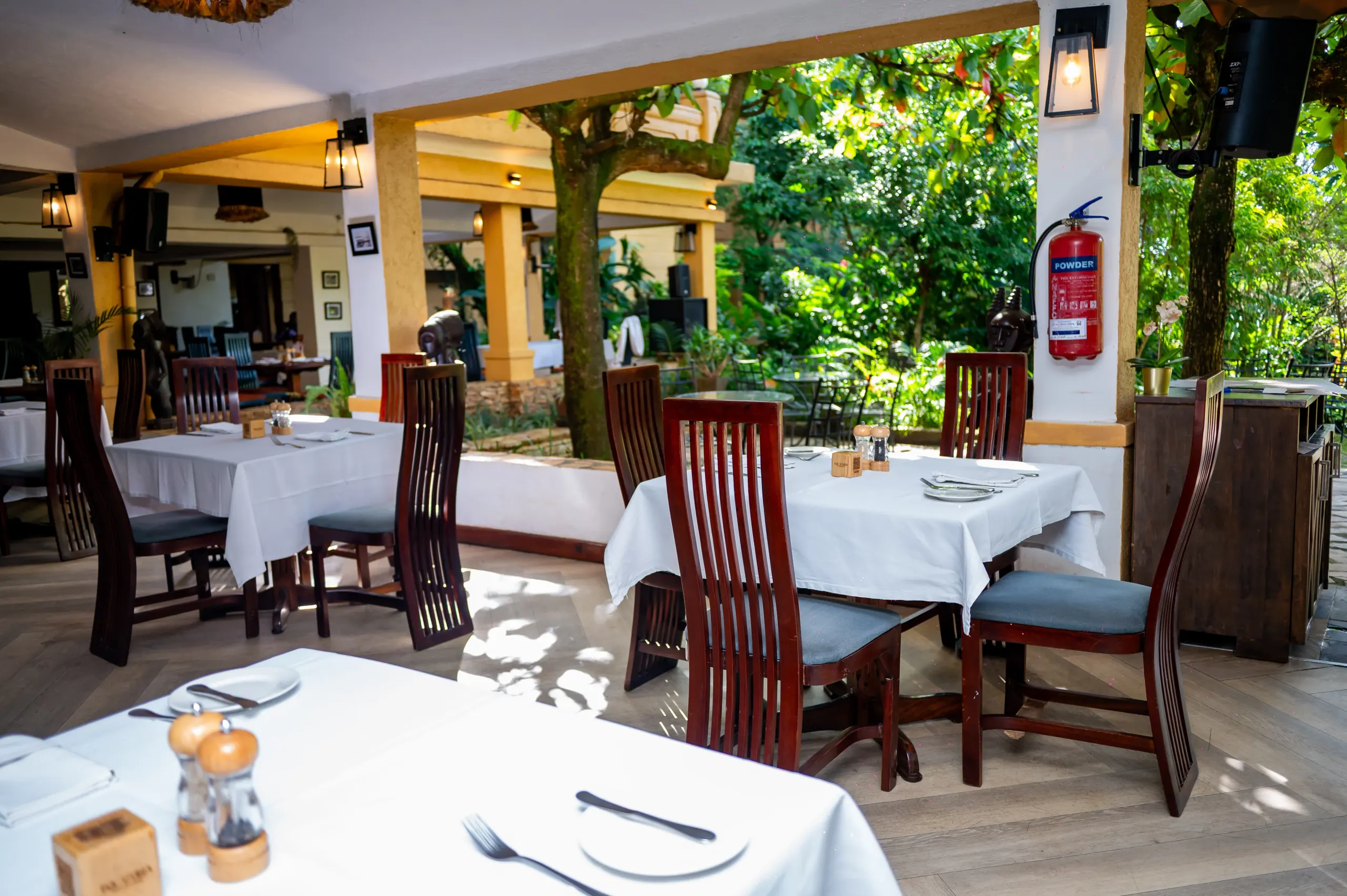 Tables under Equatoria's pergola, the garden beyond