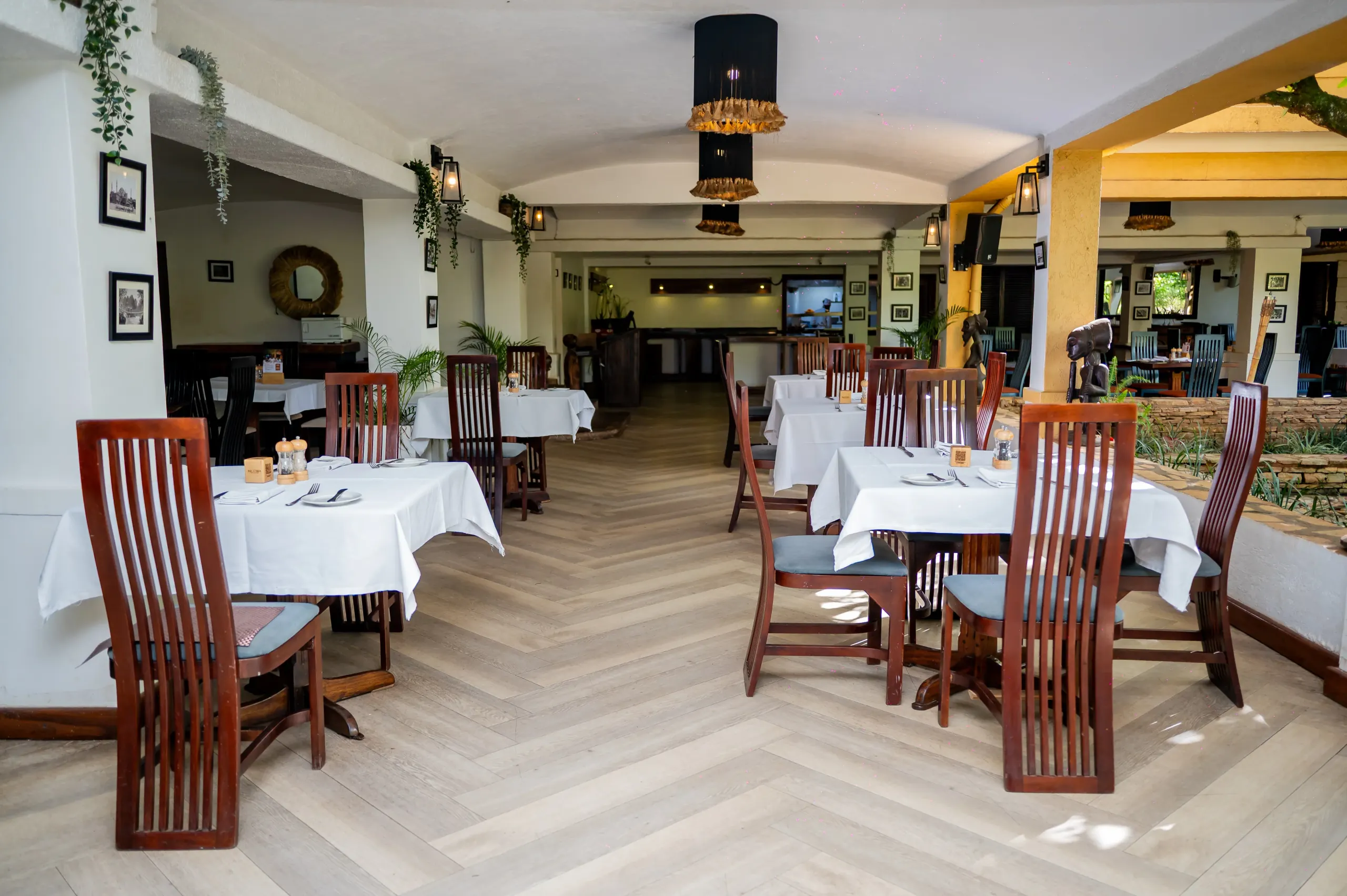 Equatoria's vaulted dining room, white linen and dark-red chairs