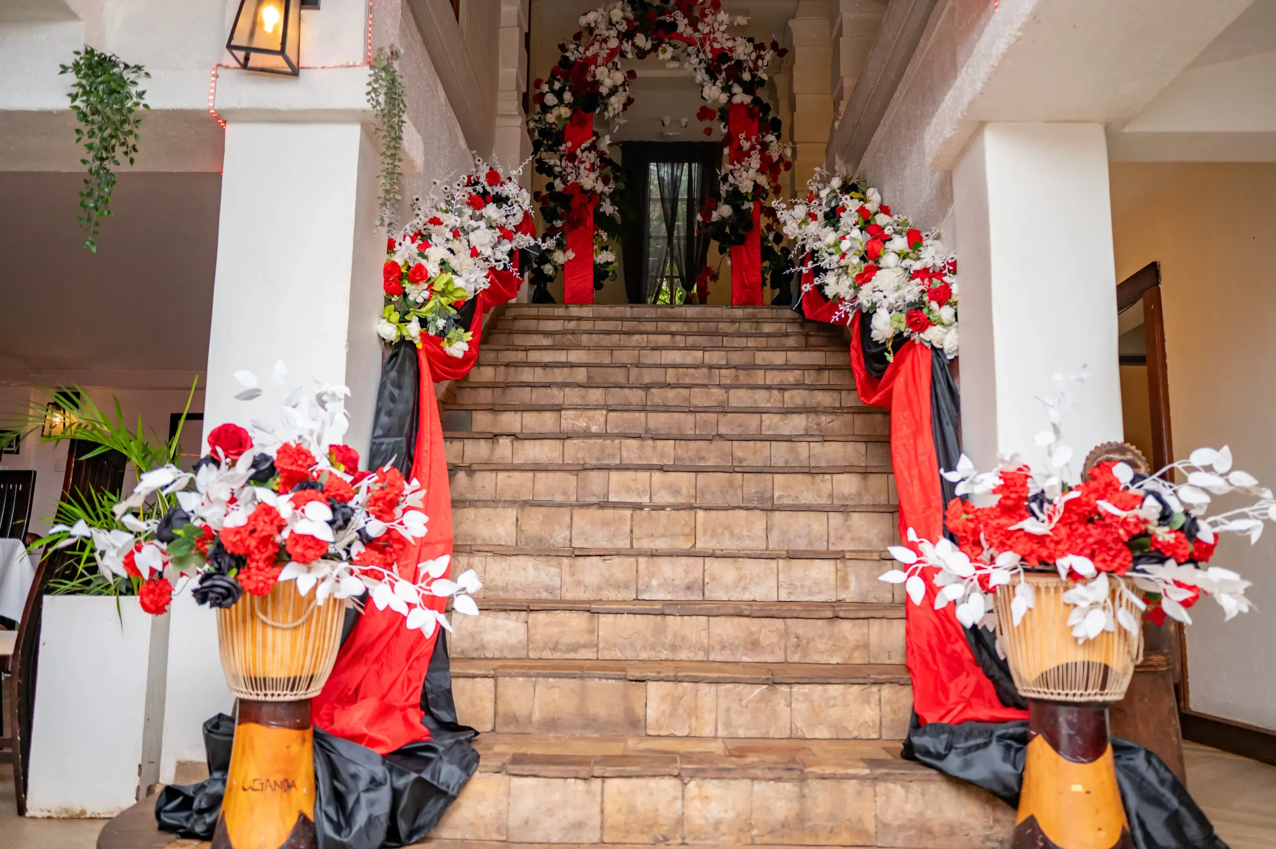 Carved drums used as plinths for floral arrangements on the stairs