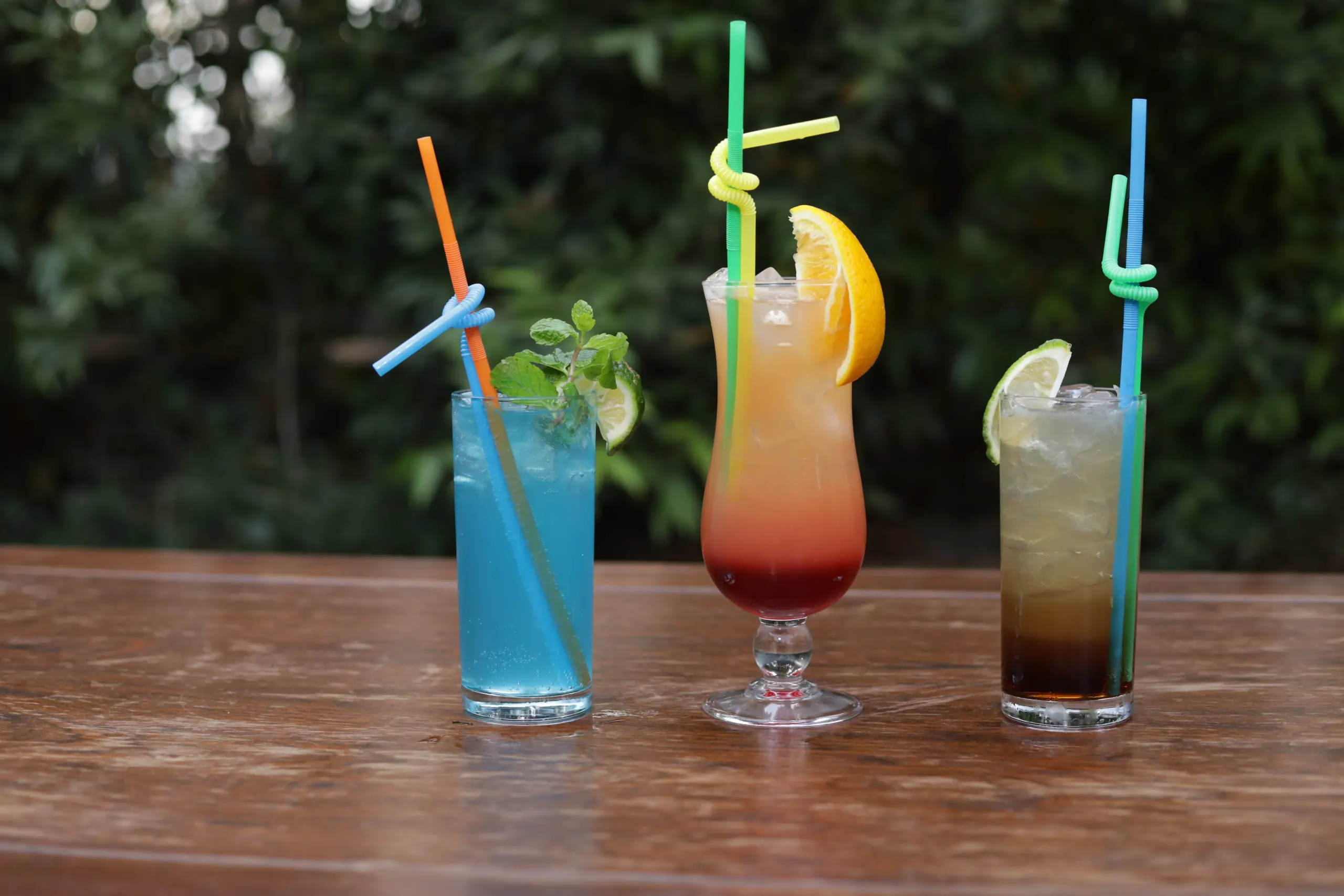 Cocktails on a timber table, the garden behind