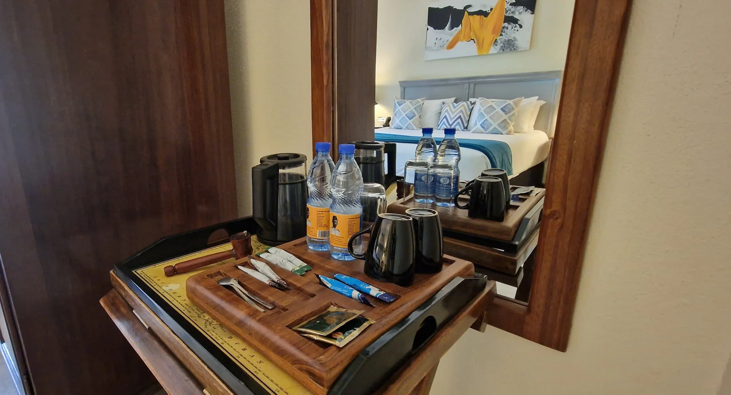 An in-room dining tray set on the desk, the bed beyond